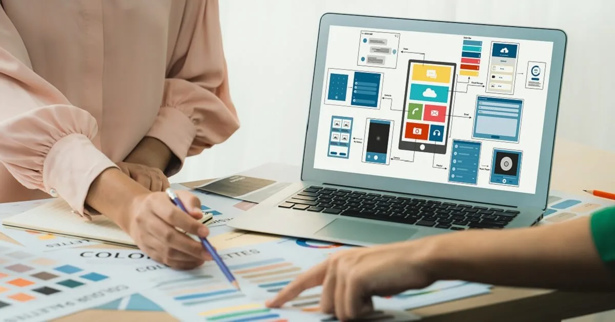 Designer recommends color while laptop displayed UI and UX designs Variegated.